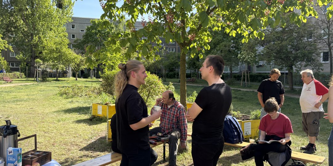 Menschengruppe unter einem Baum im Binsenhof