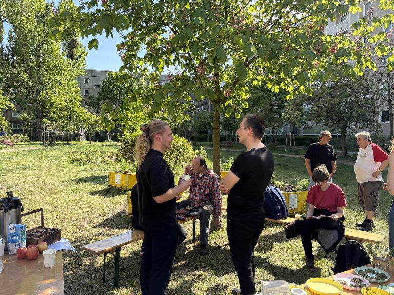 Menschengruppe unter einem Baum im Binsenhof