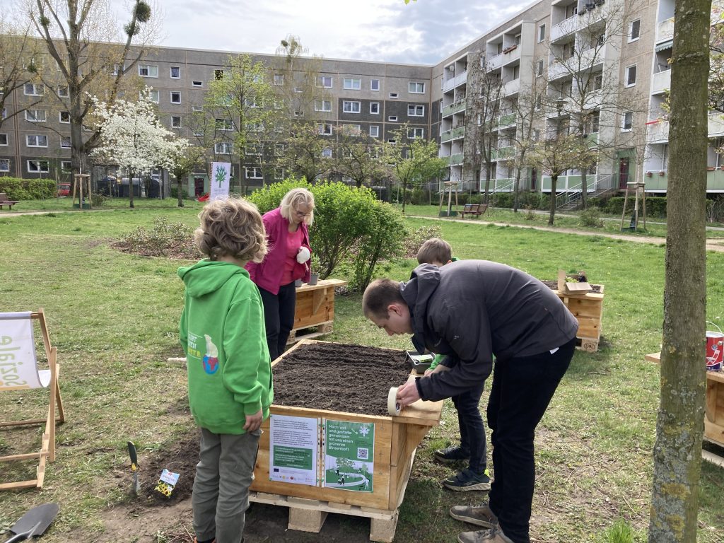 Menschen beim bepflanzen von Hochbeeten