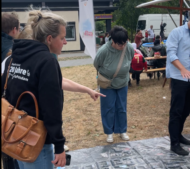 Besucher diskutieren Am Stadtteilteppich die Entwicklung Am Schlaatz